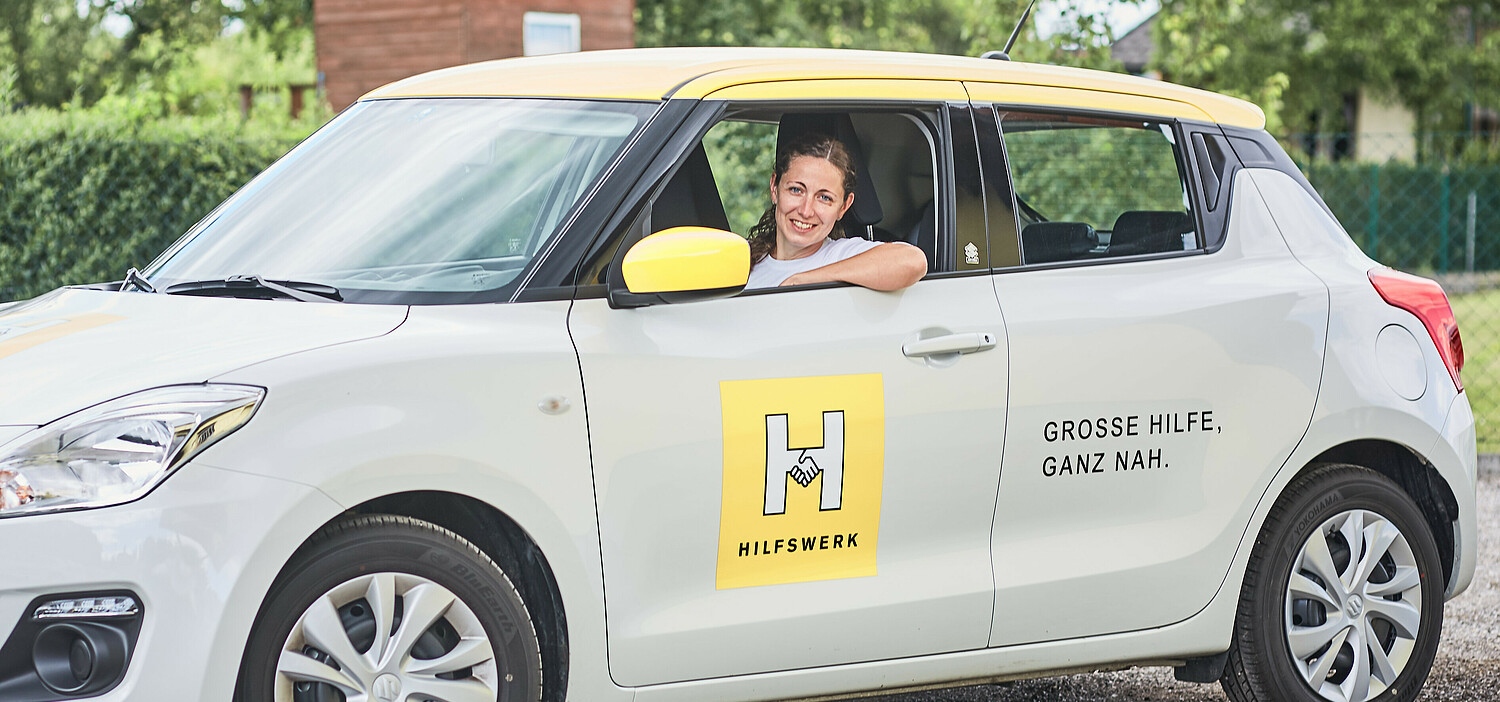 Mitarbeiterin Hilfe und Pflege daheim fährt gerade mit dem Dienstauto davon